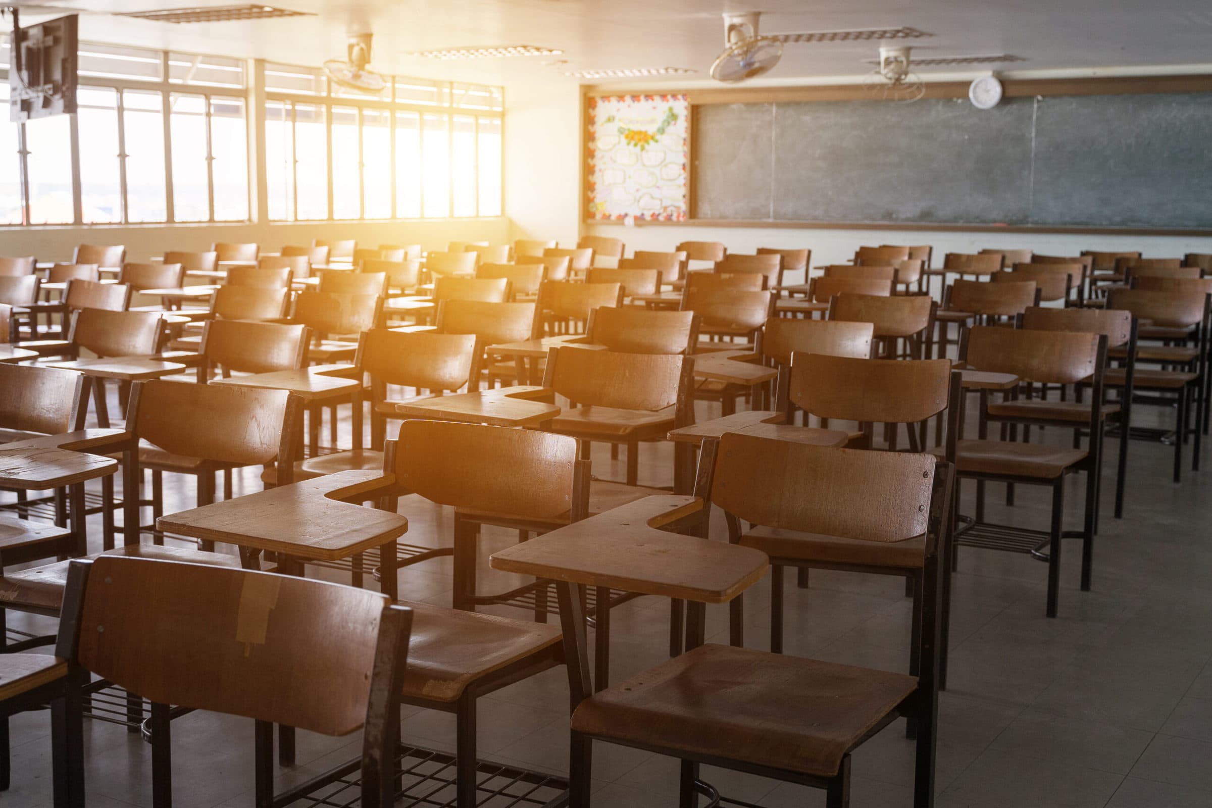 Empty classroom with vintage tone wooden chairs. Back to school concept.